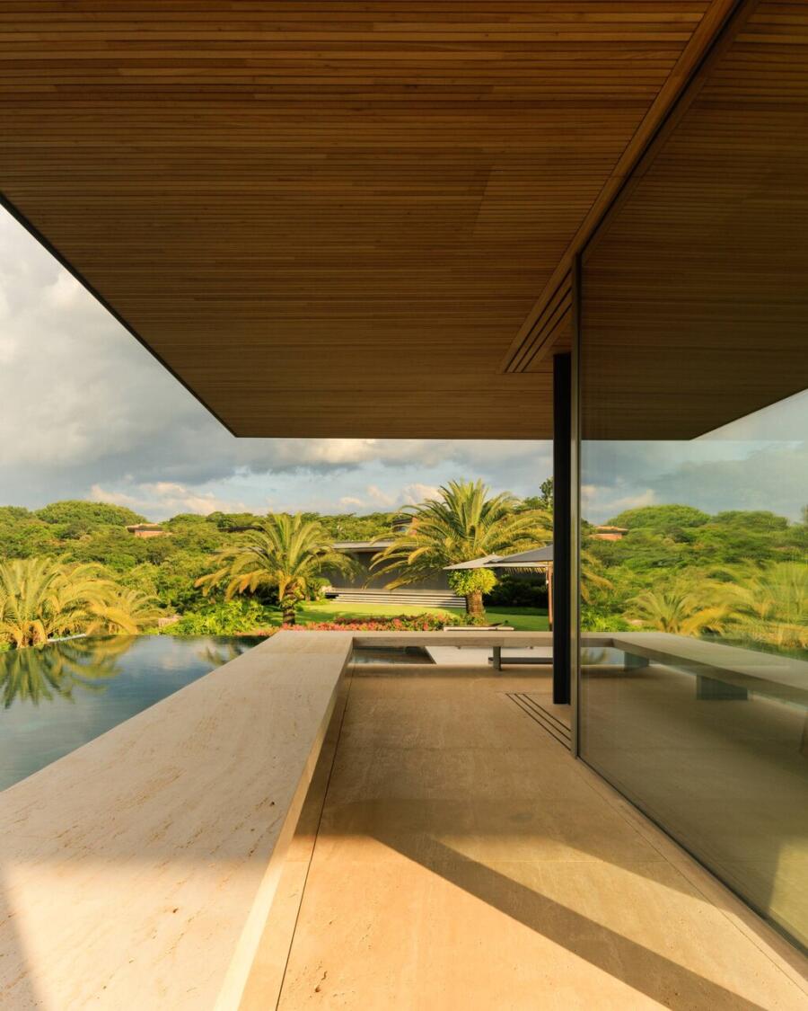 The travertine surface meeting the landscape at the threshold of the house, the pale, almost golden stone settling into the topography.